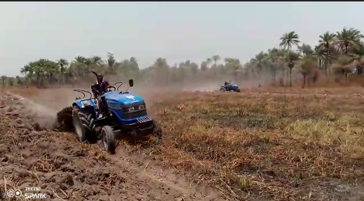 Blue tractors working in agricultural field in Sierra Leone